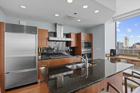 a kitchen with stainless steel appliances granite countertop a refrigerator and a sink