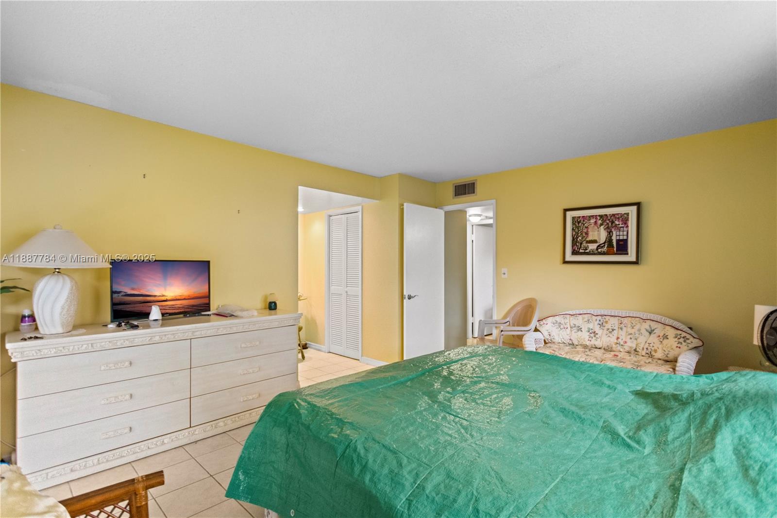 4800 Hillcrest Lane, Unit 101 Hollywood, FL 33021 - Photo 23 of 35 a bedroom with a bed and a flat tv screen on dresser