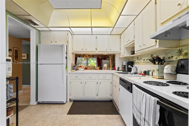 a kitchen with stainless steel appliances granite countertop a refrigerator a stove and a sink