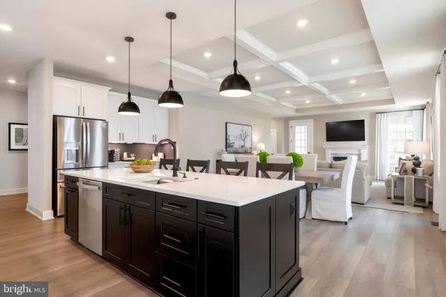 a large kitchen with lots of counter space a sink appliances and living room view