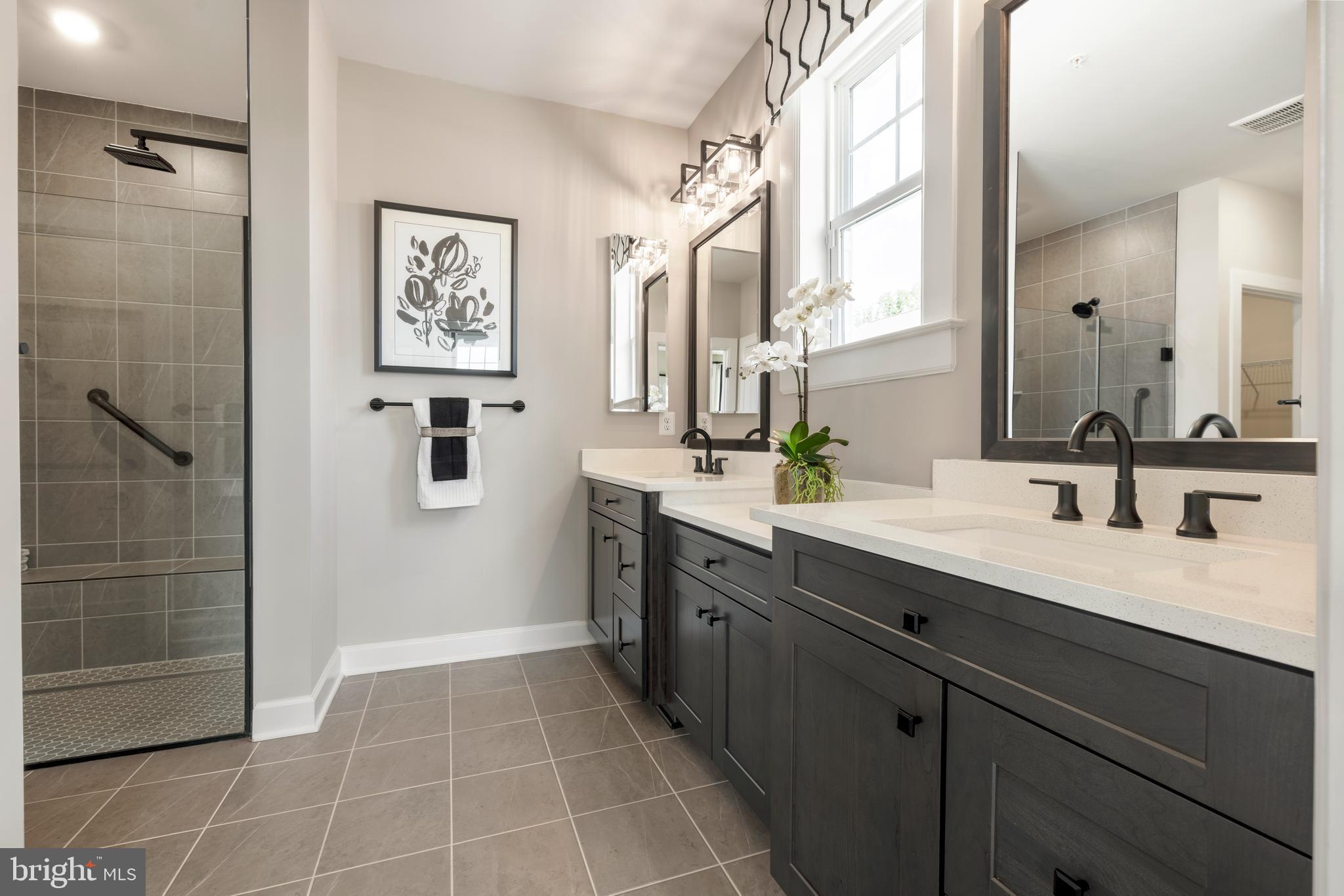 6497 Swimmer Row Way Columbia, MD 21044 - Photo 15 of 41 a spacious bathroom with a double vanity sink a mirror and a shower