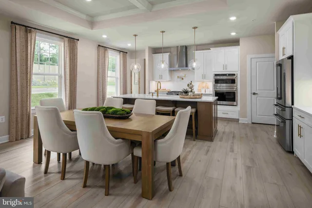 a view of a dining room with furniture a kitchen and chandelier