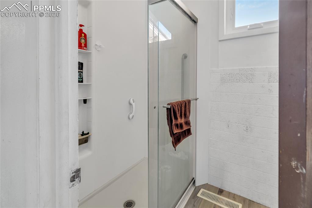 68300 Highway 50 Fowler, CO 81039 - Photo 13 of 49 Full bath featuring a stall shower, tile walls, wainscoting, and light wood finished floors