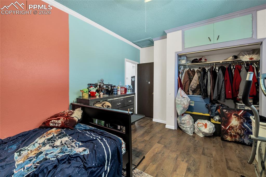 68300 Highway 50 Fowler, CO 81039 - Photo 14 of 49 Bedroom with dark wood-style floors, a textured ceiling, a closet, and crown molding