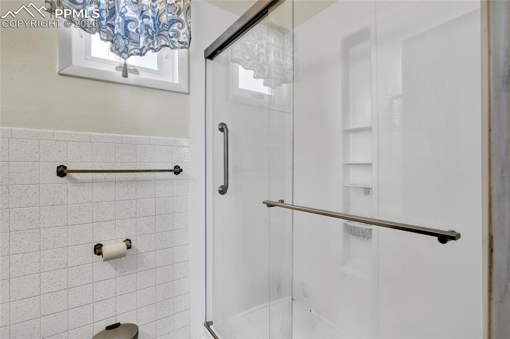 68300 Highway 50 Fowler, CO 81039 - Photo 17 of 49 Full bathroom with tile walls, a shower stall, and wainscoting