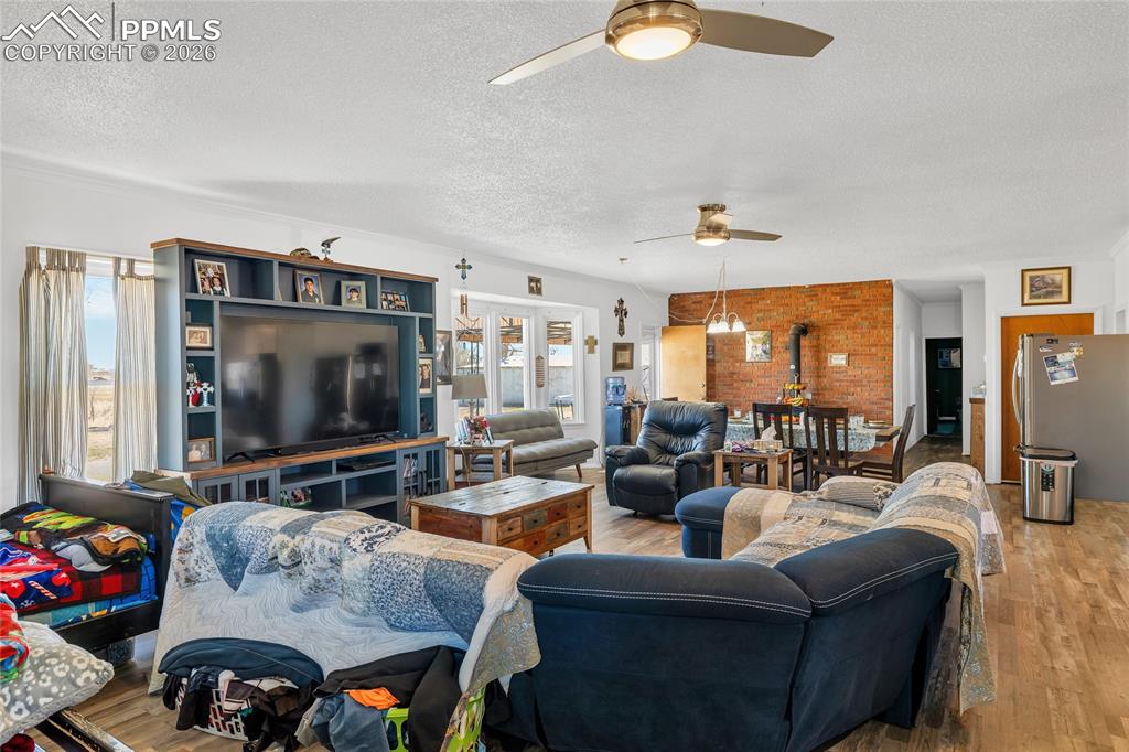 68300 Highway 50 Fowler, CO 81039 - Photo 24 of 49 Living room featuring wood finished floors, a textured ceiling, and ceiling fan