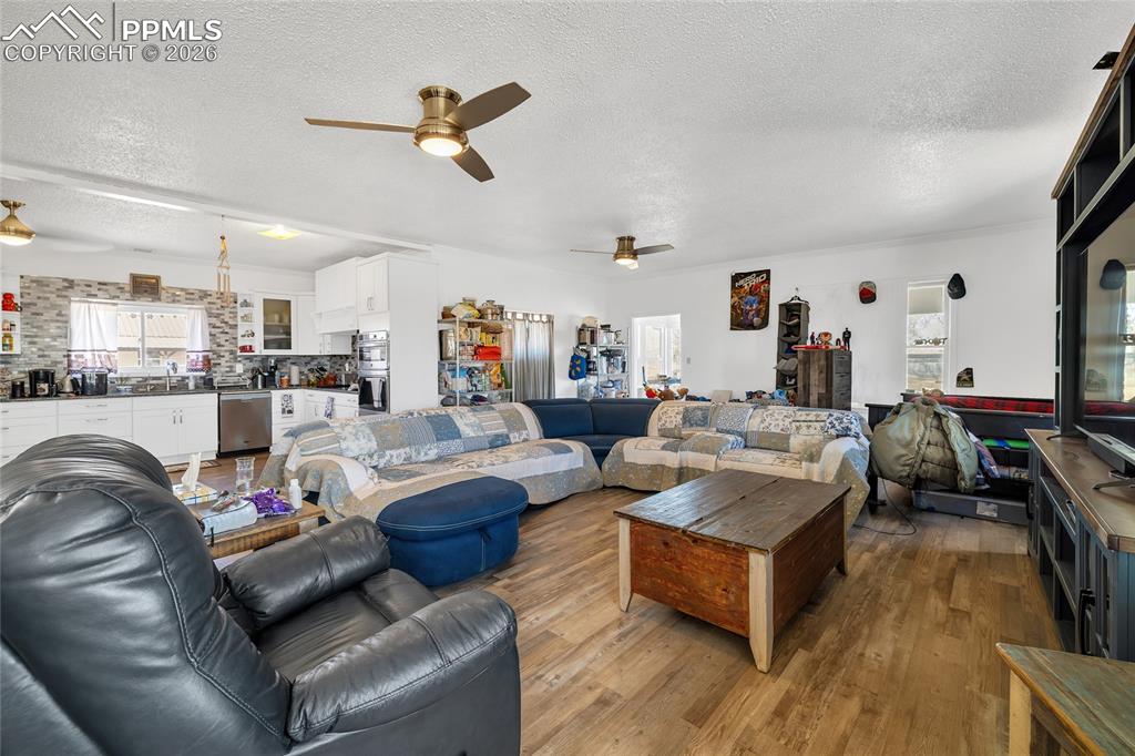 68300 Highway 50 Fowler, CO 81039 - Photo 25 of 49 Living area featuring plenty of natural light, a textured ceiling, hardwood / wood-style flooring, and ceiling fan