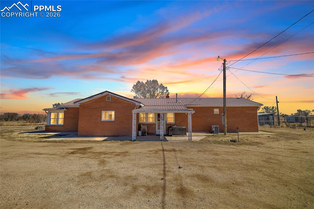 68300 Highway 50 Fowler, CO 81039 - Photo 3 of 47 Back of property at dusk with brick siding and a patio