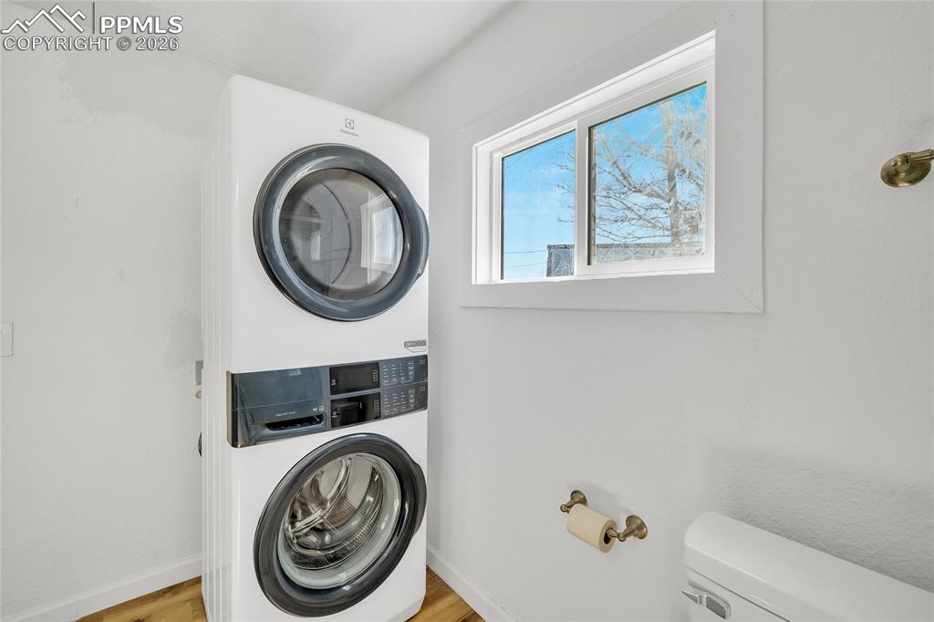 68300 Highway 50 Fowler, CO 81039 - Photo 34 of 49 ADU Laundry area featuring stacked washer / dryer and light wood-style flooring