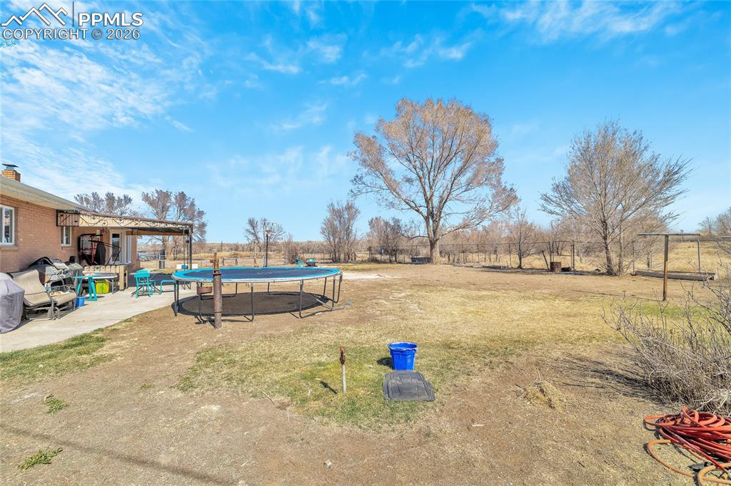 68300 Highway 50 Fowler, CO 81039 - Photo 47 of 49 Fenced backyard with a trampoline and a patio