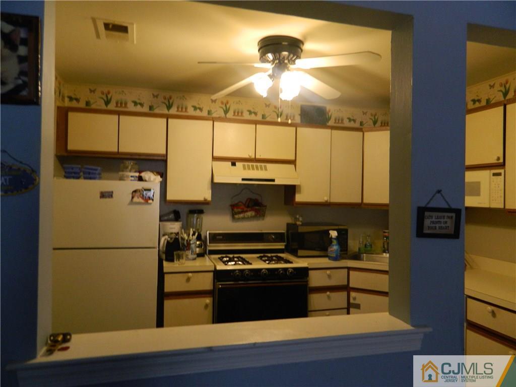 110 Raintree Court, Unit 110 Helmetta, NJ 08828 - Photo 2 of 5 a kitchen with a refrigerator and a stove