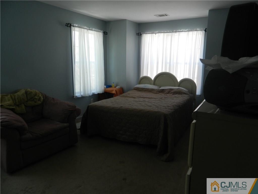 110 Raintree Court, Unit 110 Helmetta, NJ 08828 - Photo 5 of 5 a bed sitting in a bedroom next to a window