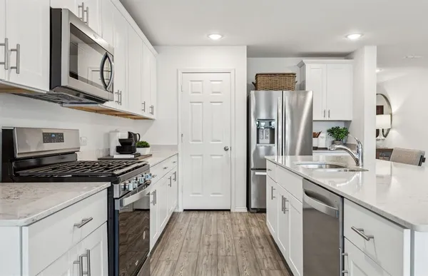 a kitchen with stainless steel appliances granite countertop a stove a sink and a refrigerator