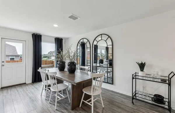 a dining room with furniture and wooden floor