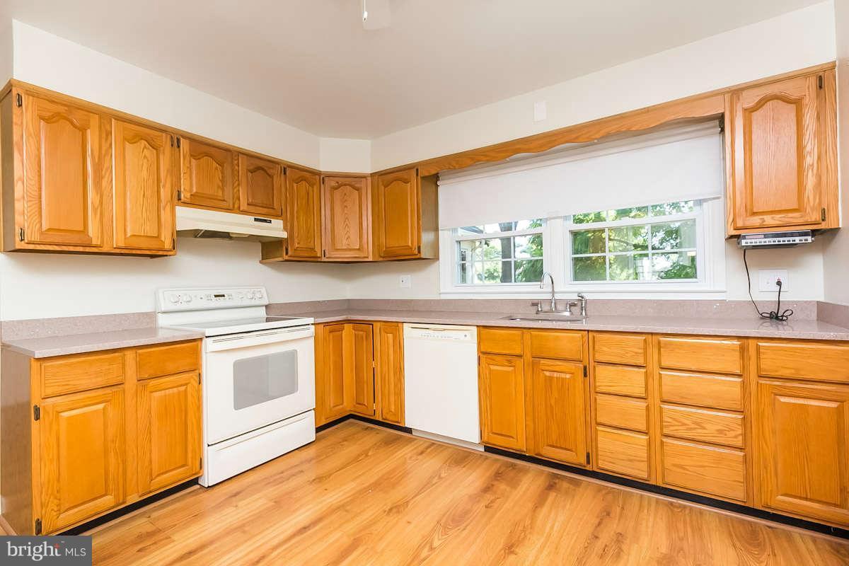 7722 Trappe Road Dundalk, MD 21222 - Photo 7 of 27 a kitchen with stainless steel appliances granite countertop a sink a stove cabinets and a window
