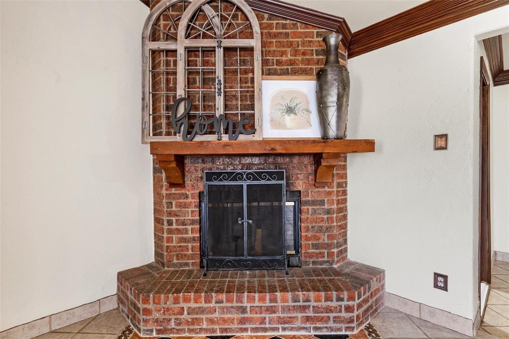 3433 West Tours Road West, TX 76691 - Photo 9 of 40 Detailed view of a brick fireplace and crown molding