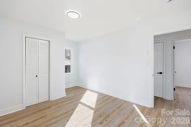 a view of a room with wooden floor and window