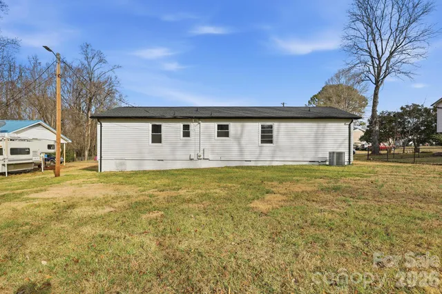 a front view of house with yard and trees in the background