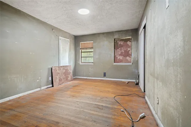 a view of a room with a large window ceiling fan and wooden floor