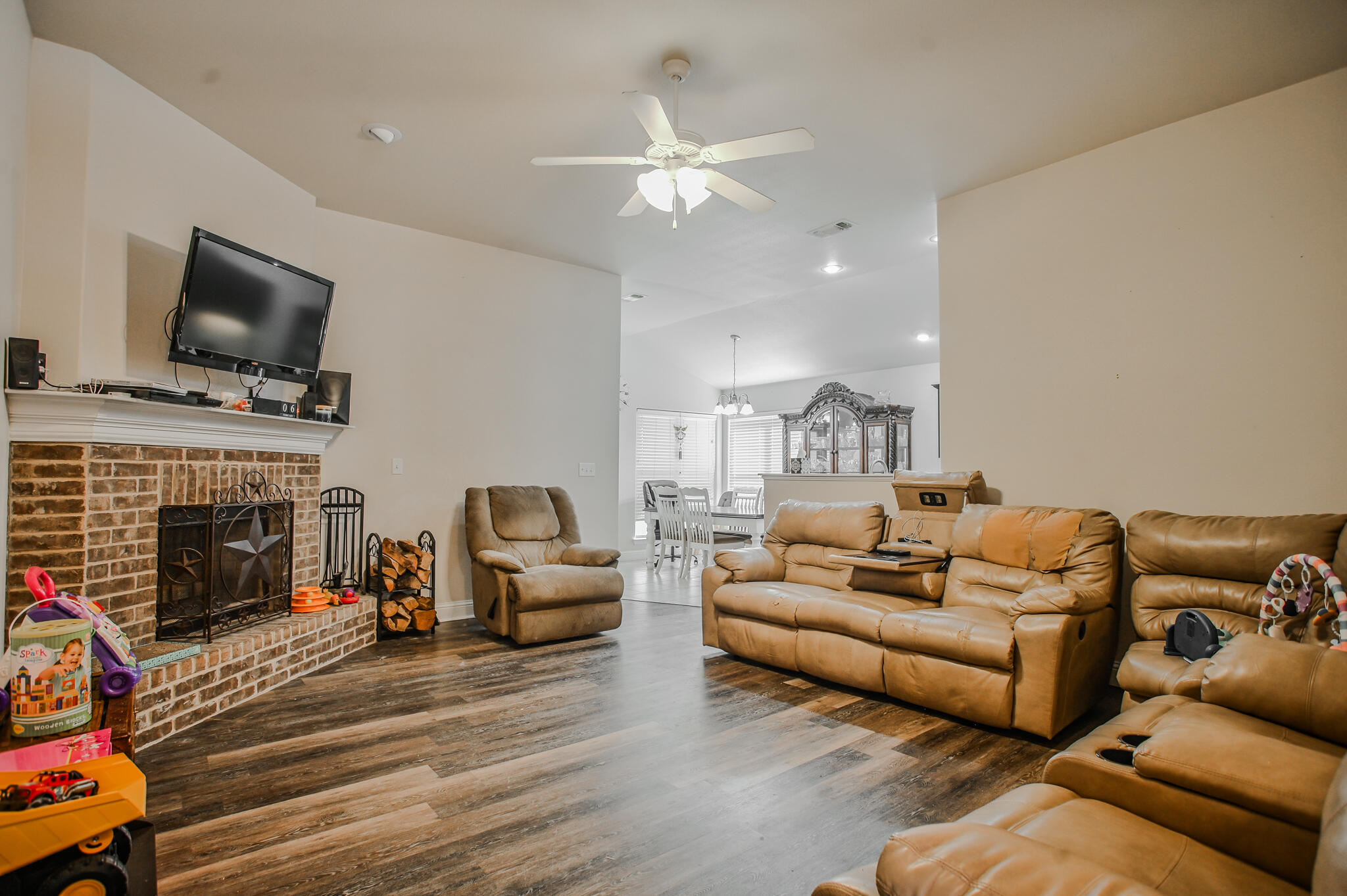 3637 Ridgely Avenue Lubbock, TX 79407 - Photo 4 of 37 a living room with furniture a fireplace and a flat screen tv
