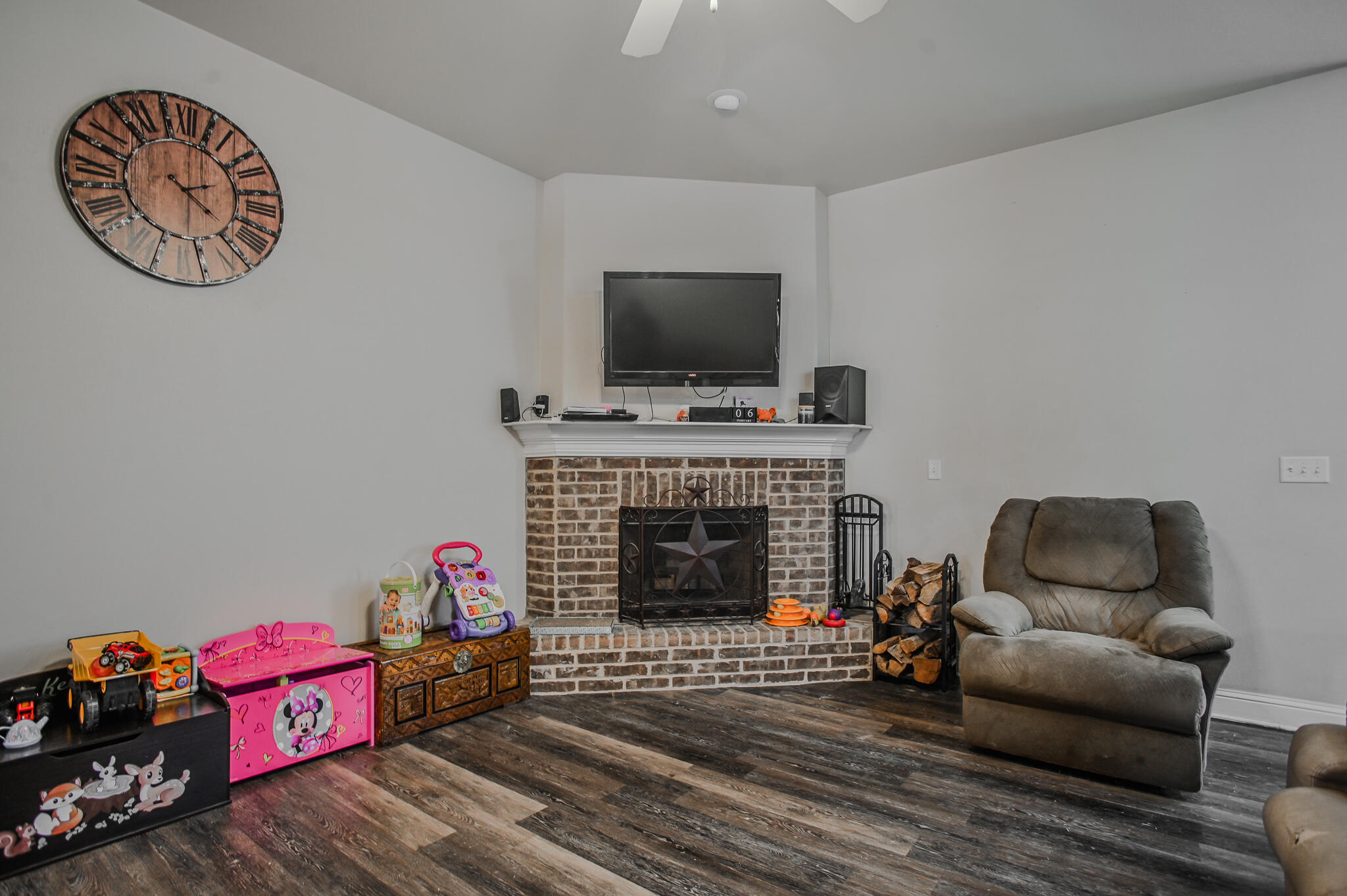 3637 Ridgely Avenue Lubbock, TX 79407 - Photo 8 of 37 a living room with furniture a flat screen tv and a fireplace