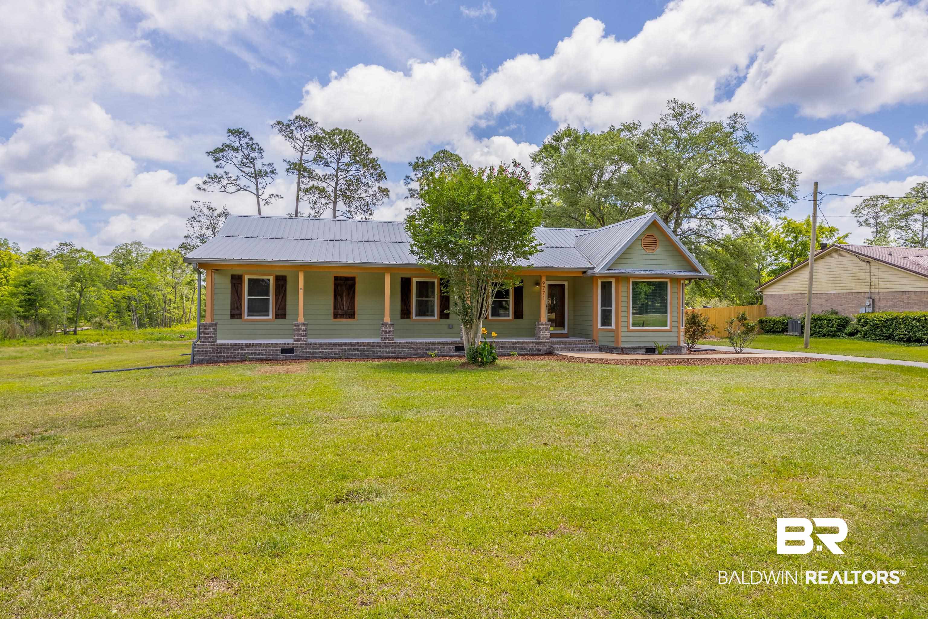 9771 Clarke Ridge Road Foley, AL 36535 - Photo 2 of 72 Single-story home with metal roof, a porch, and front yard.