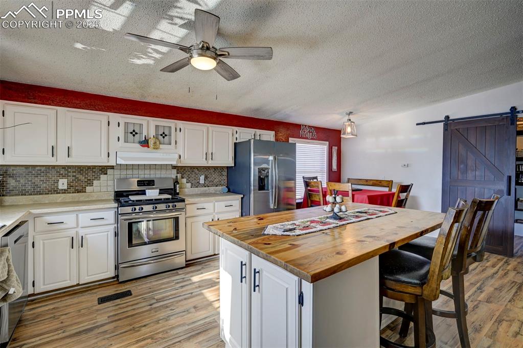 35355 Funk Road Calhan, CO 80808 - Photo 11 of 31 a kitchen with stainless steel appliances kitchen island granite countertop a table chairs stove and cabinets