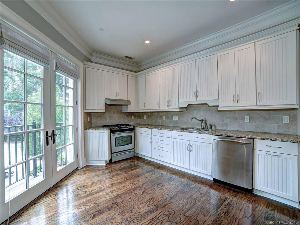 2823 Providence Road, Unit 121 Charlotte, NC 28211 - Photo 8 of 22 a kitchen with granite countertop a stove top oven sink and cabinets