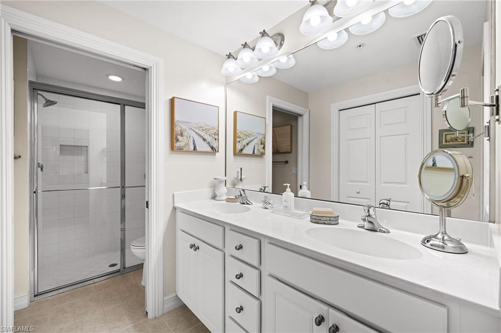 9128 Michael Circle, Unit 9 Naples, FL 34113 - Photo 12 of 50 Bathroom featuring tile flooring, toilet, double sink vanity, and a shower with shower door
