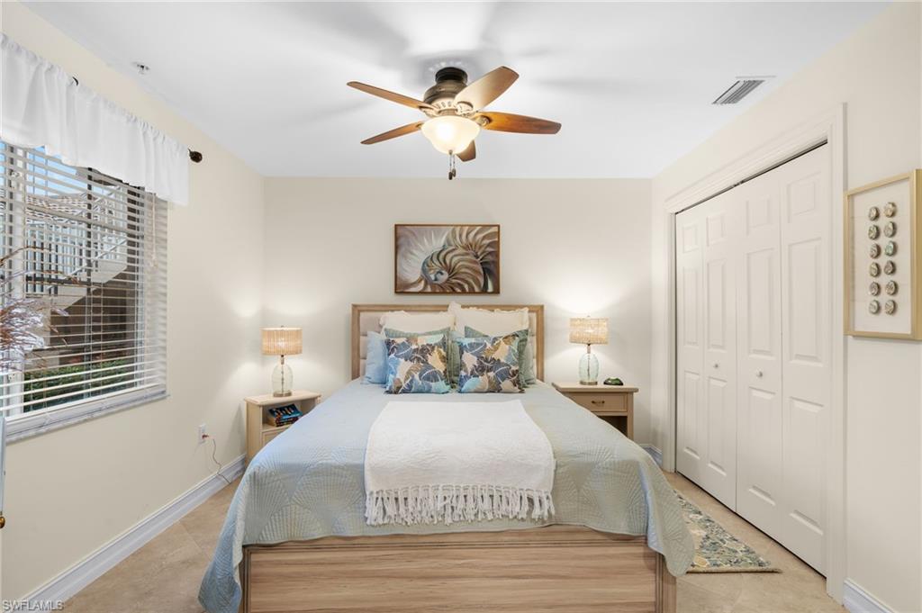 9128 Michael Circle, Unit 9 Naples, FL 34113 - Photo 17 of 50 Tiled bedroom with a closet, ceiling fan, and multiple windows