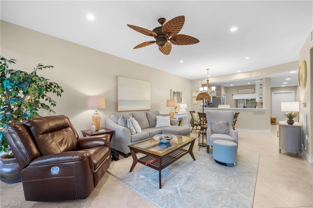 9128 Michael Circle, Unit 9 Naples, FL 34113 - Photo 18 of 50 Living room featuring light tile floors and ceiling fan with notable chandelier