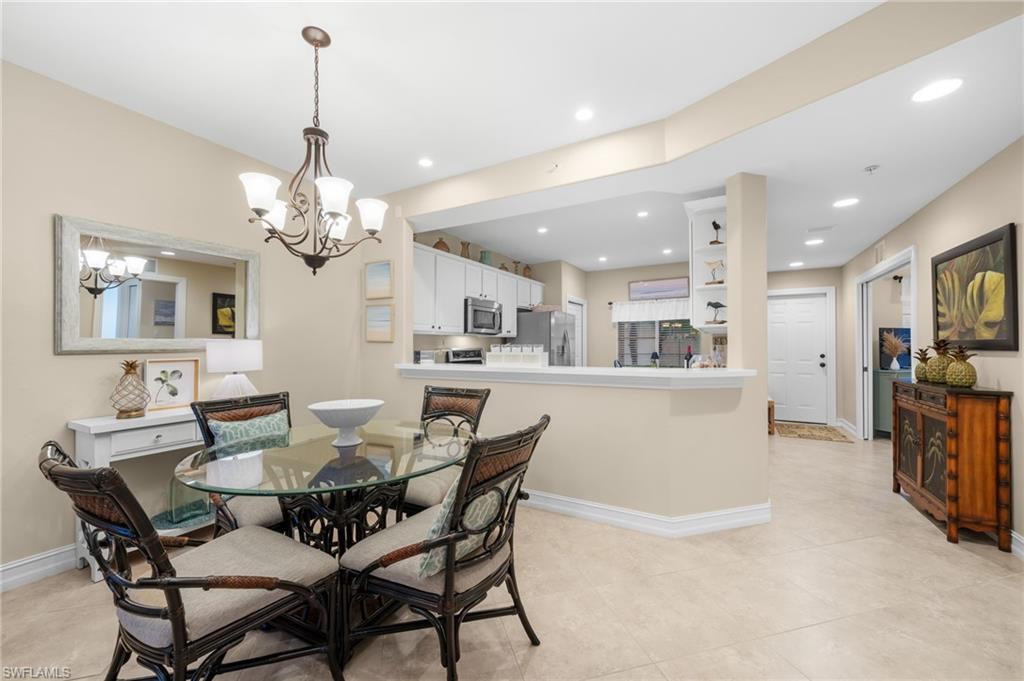 9128 Michael Circle, Unit 9 Naples, FL 34113 - Photo 20 of 50 Dining space with a chandelier and light tile floors