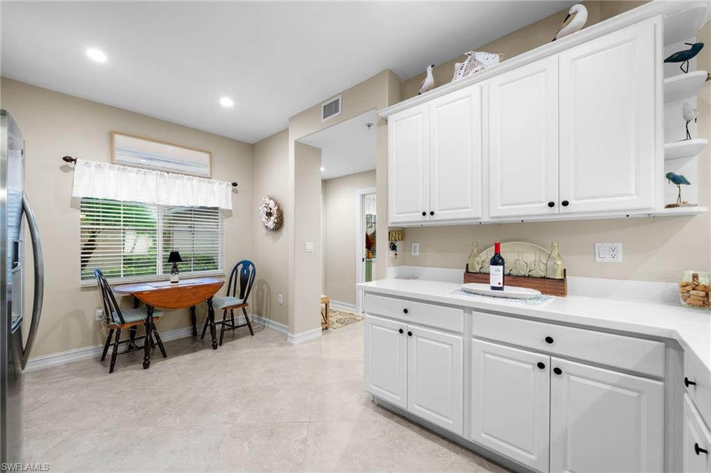 9128 Michael Circle, Unit 9 Naples, FL 34113 - Photo 23 of 50 Kitchen featuring white cabinets, stainless steel fridge, and light tile floors