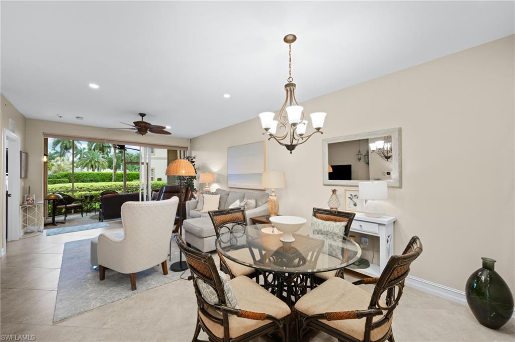 9128 Michael Circle, Unit 9 Naples, FL 34113 - Photo 6 of 50 Tiled dining room featuring ceiling fan with notable chandelier