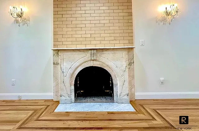 a view of a livingroom with a fireplace and chandelier