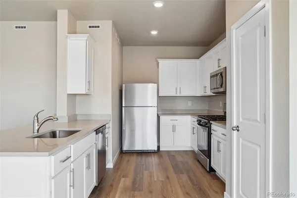 a kitchen with white cabinets and stainless steel appliances