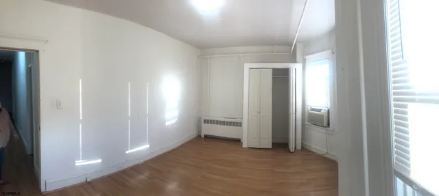 a view of an empty room with glass door and windows