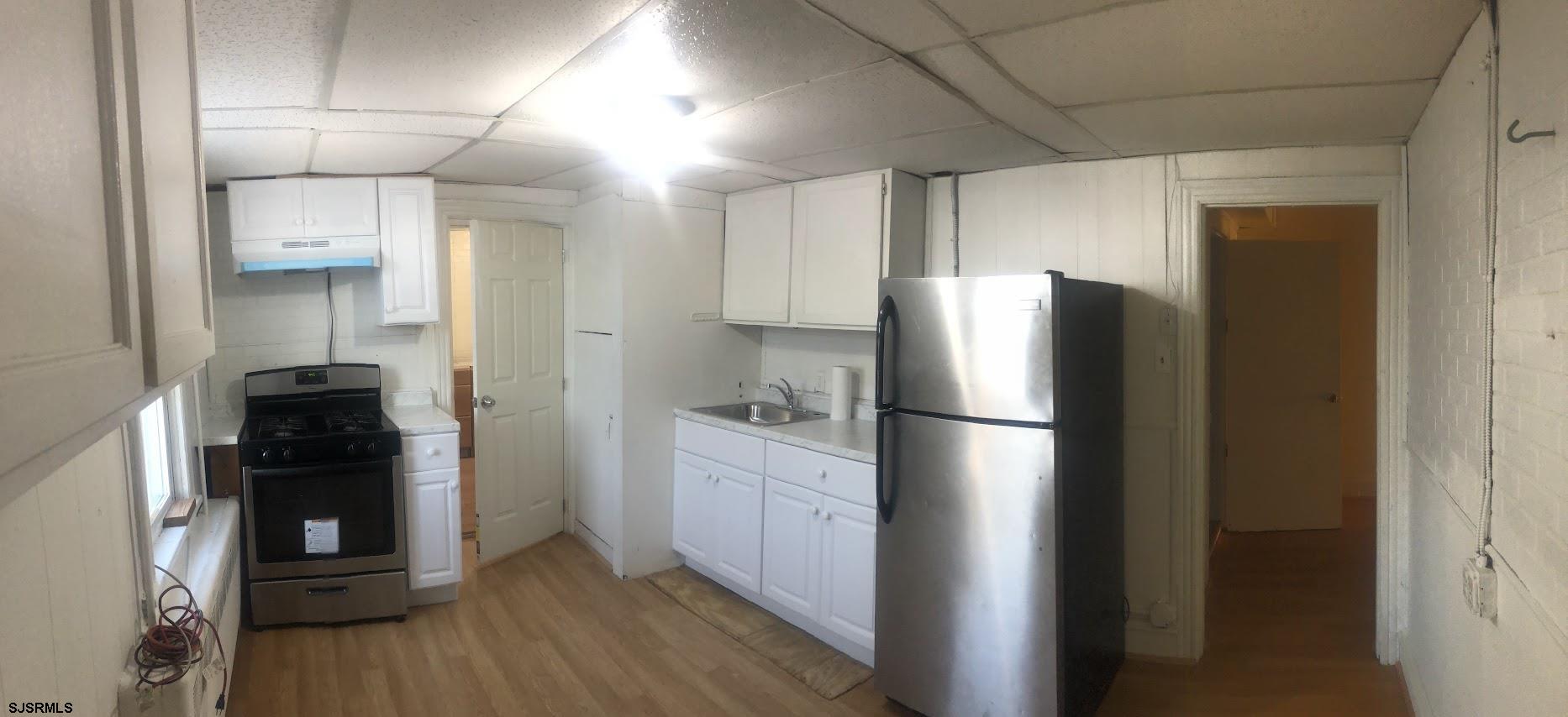 85-91 North Main Street, Unit A Pleasantville, NJ 08232 - Photo 7 of 10 a kitchen with stainless steel appliances a refrigerator a stove and wooden floor