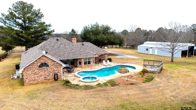 a view of a house with swimming pool and sitting area