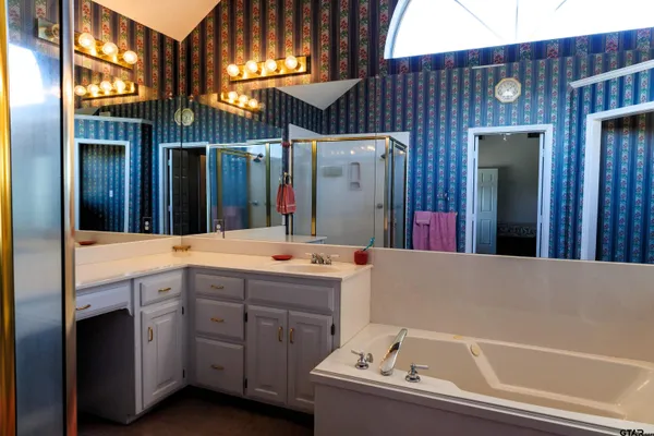 a bathroom with a tub sink and mirror