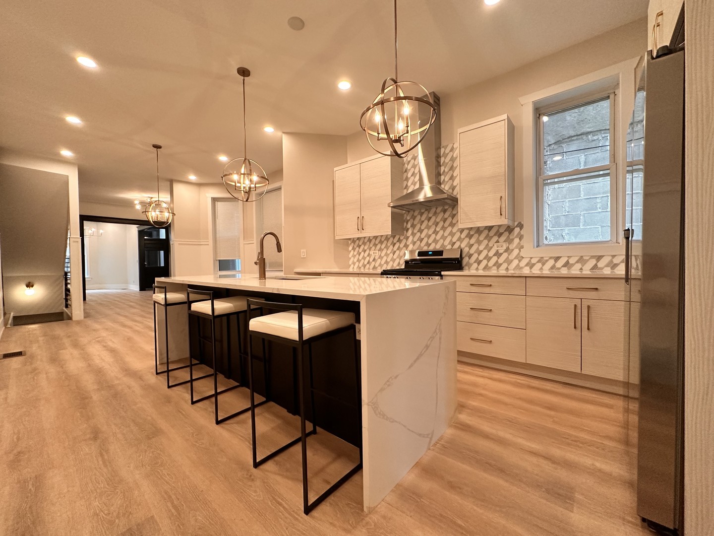 4409 South Prairie Avenue Chicago, IL 60653 - Photo 21 of 44 a kitchen with stainless steel appliances kitchen island granite countertop a table chairs sink and wooden floor