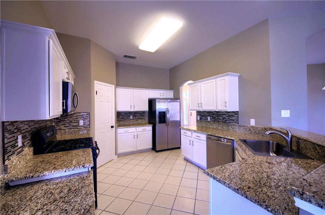 129 Copperwood Loop Round Rock, TX 78665 - Photo 16 of 30 a kitchen with stainless steel appliances granite countertop a sink stove and refrigerator