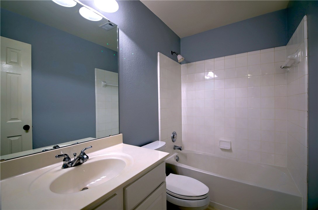 129 Copperwood Loop Round Rock, TX 78665 - Photo 18 of 30 a bathroom with a sink a toilet a mirror and shower