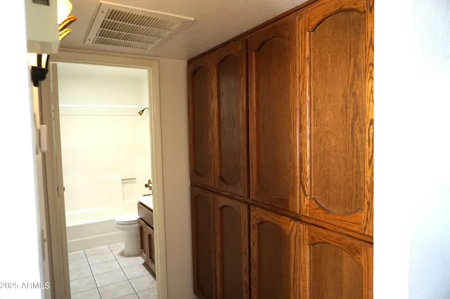 a view of an empty room with cabinet and wooden floor
