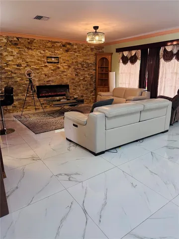 a living room with fireplace furniture and a floor to ceiling window