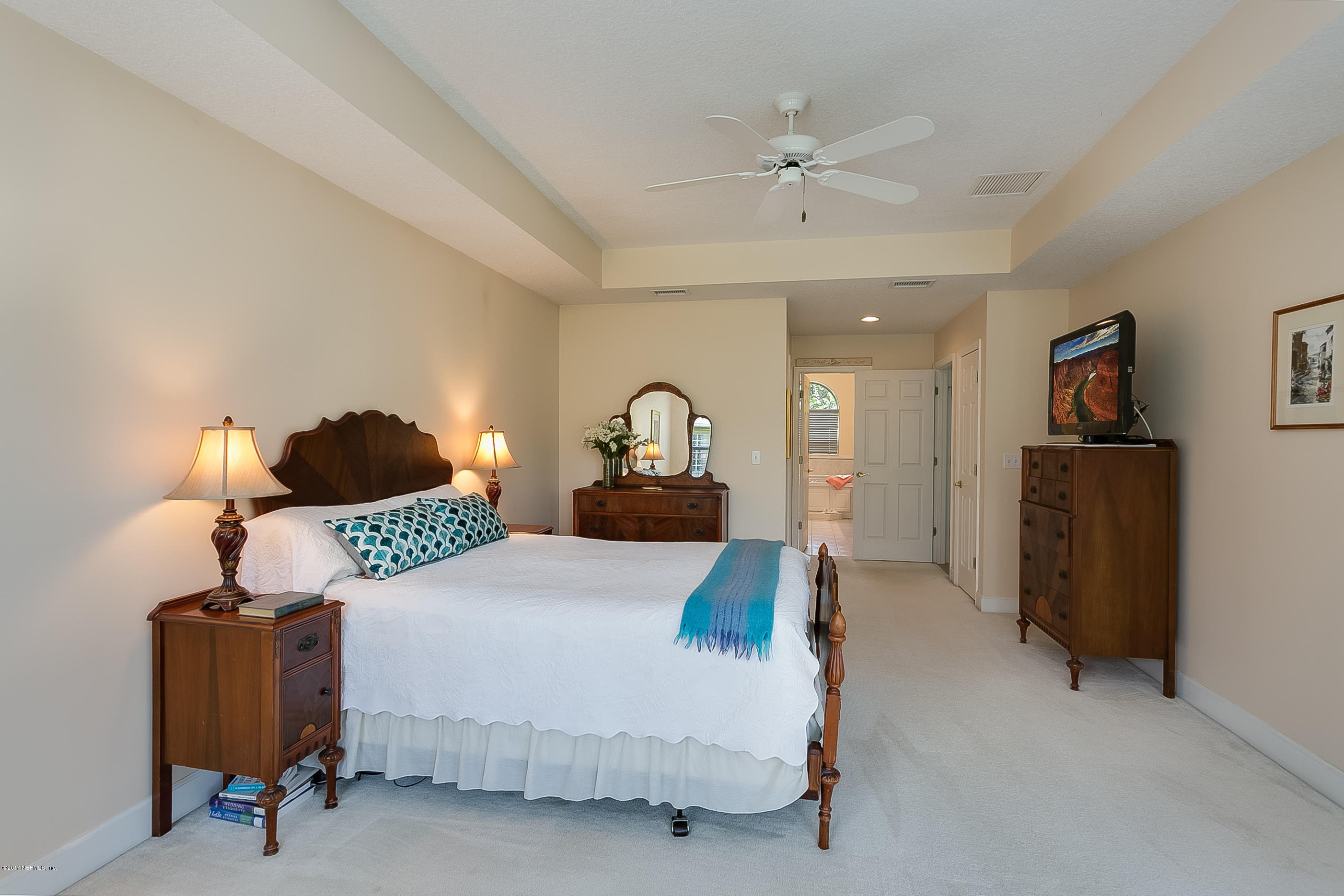 261 North Mill View Way Ponte Vedra Beach, FL 32082 - Photo 13 of 27 a bedroom with a bed mirror and a lamp