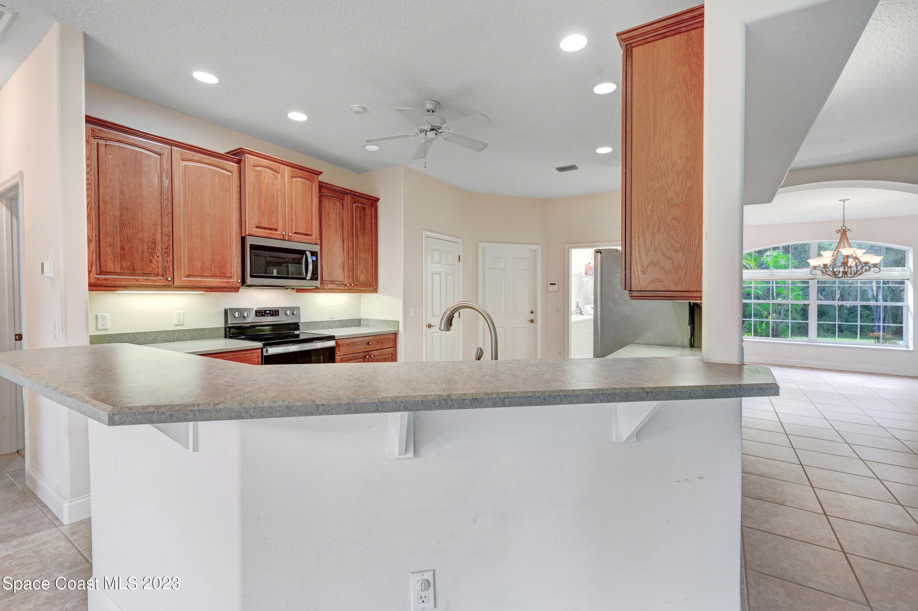1074 Gray Road Cocoa, FL 32926 - Photo 16 of 47 a kitchen with stainless steel appliances granite countertop a stove a sink and a microwave