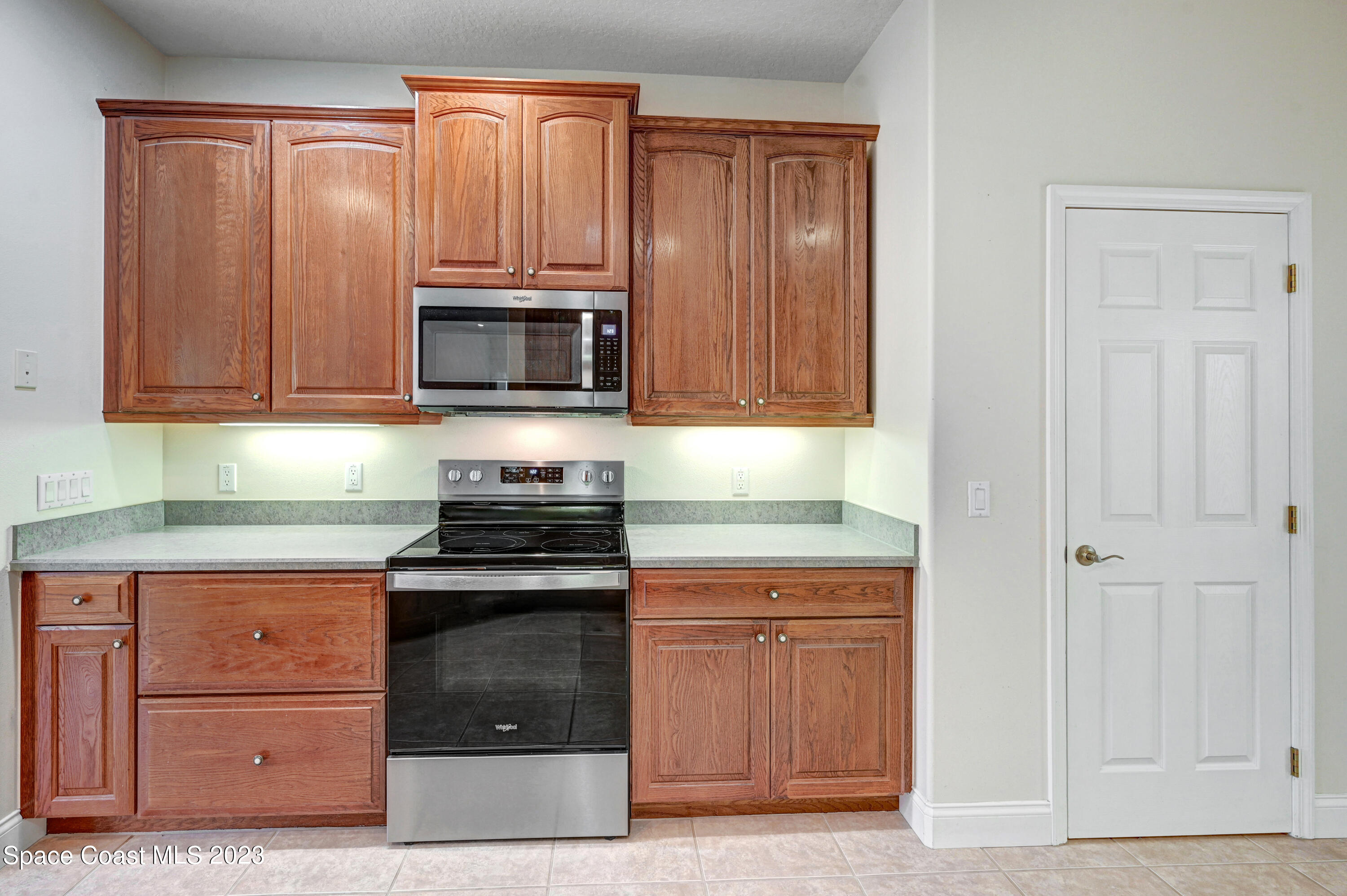1074 Gray Road Cocoa, FL 32926 - Photo 18 of 47 a kitchen with granite countertop wood cabinets and stainless steel appliances