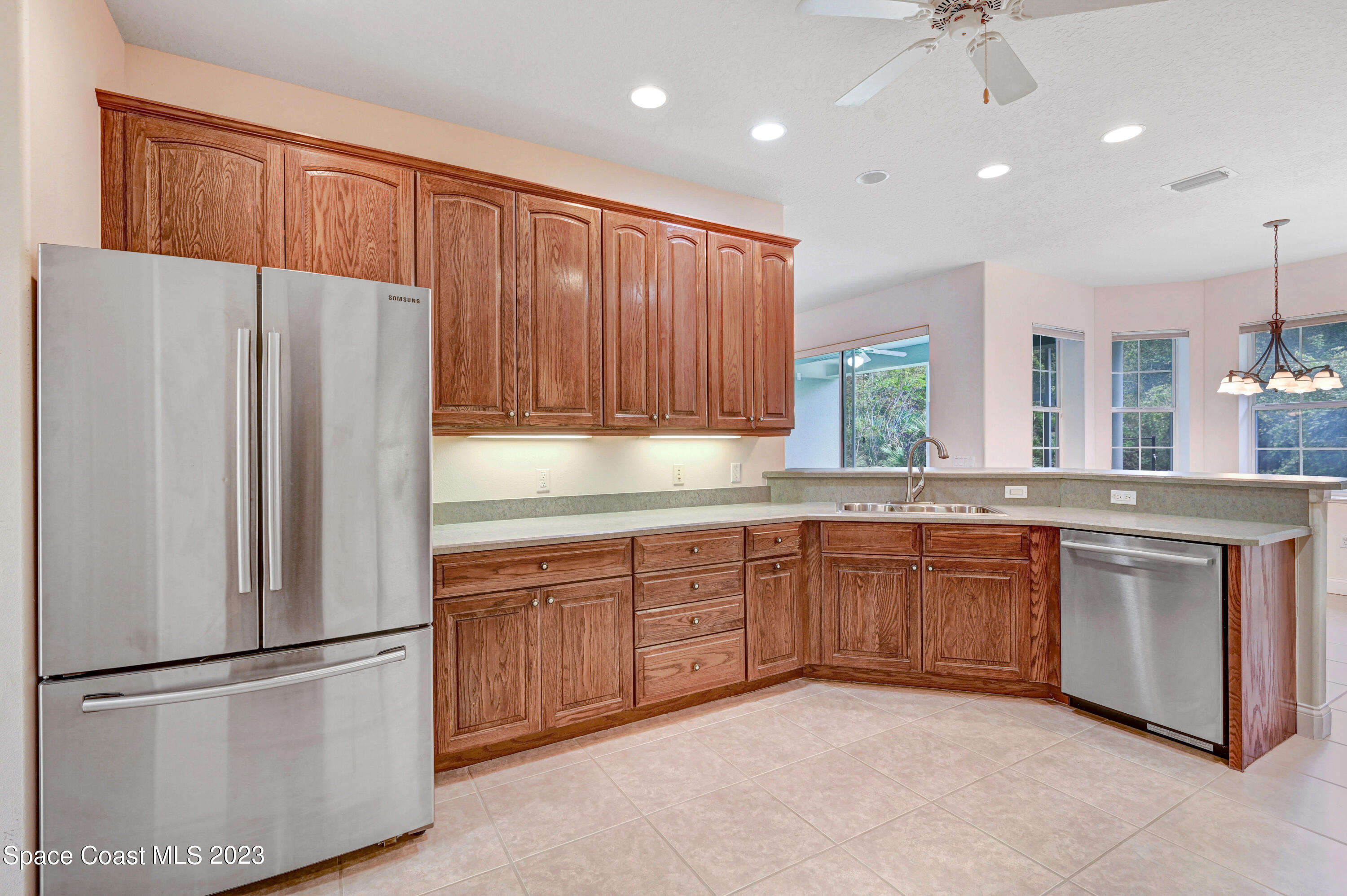 1074 Gray Road Cocoa, FL 32926 - Photo 19 of 47 a kitchen with stainless steel appliances granite countertop a refrigerator a sink dishwasher a stove with wooden cabinets and floor