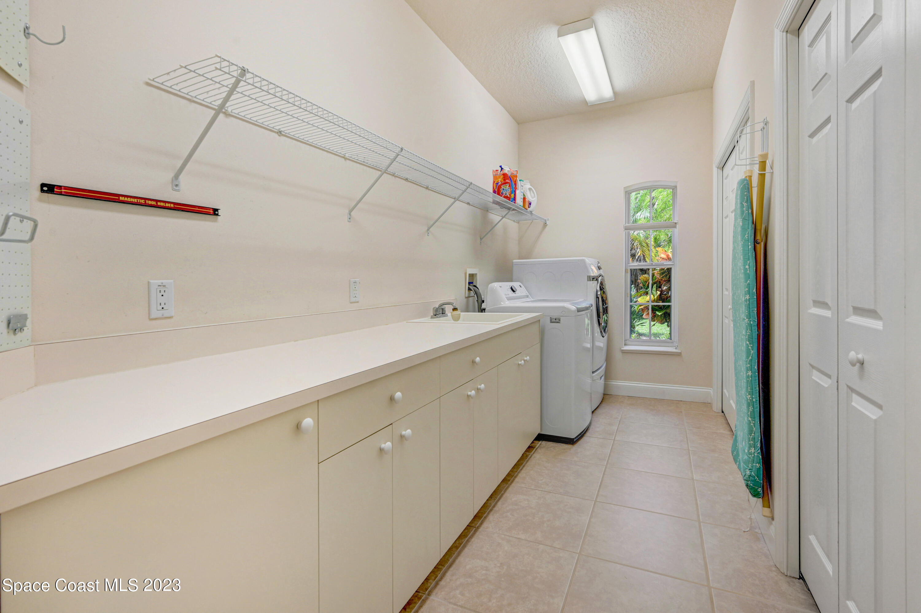 1074 Gray Road Cocoa, FL 32926 - Photo 24 of 47 a utility room with cabinets washer and dryer
